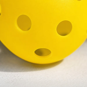 Close-up of a yellow outdoor pickleball