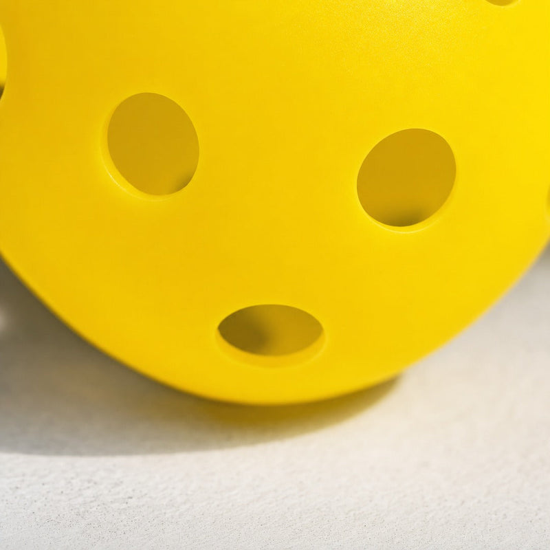 Close-up of a yellow outdoor pickleball