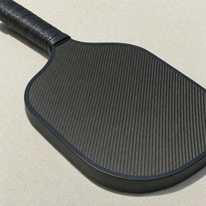 Close-up of a carbon pickleball paddle face and edge