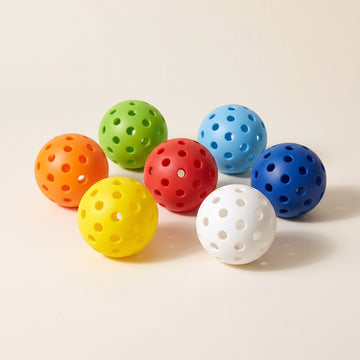 Seven outdoor pickleballs in yellow, orange, red, green, light blue, blue and white