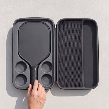Black paddle placed in the moulded recess of the open hardshell case